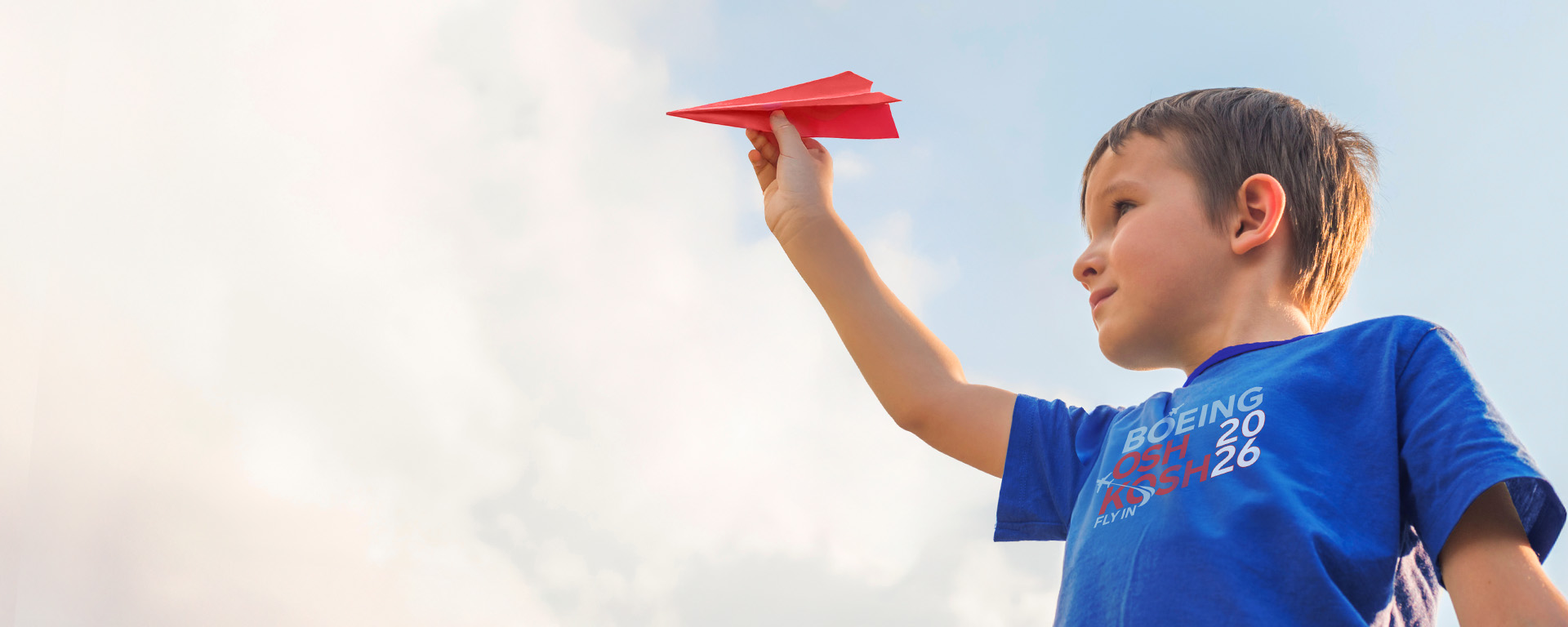 Child playing with paper airplane