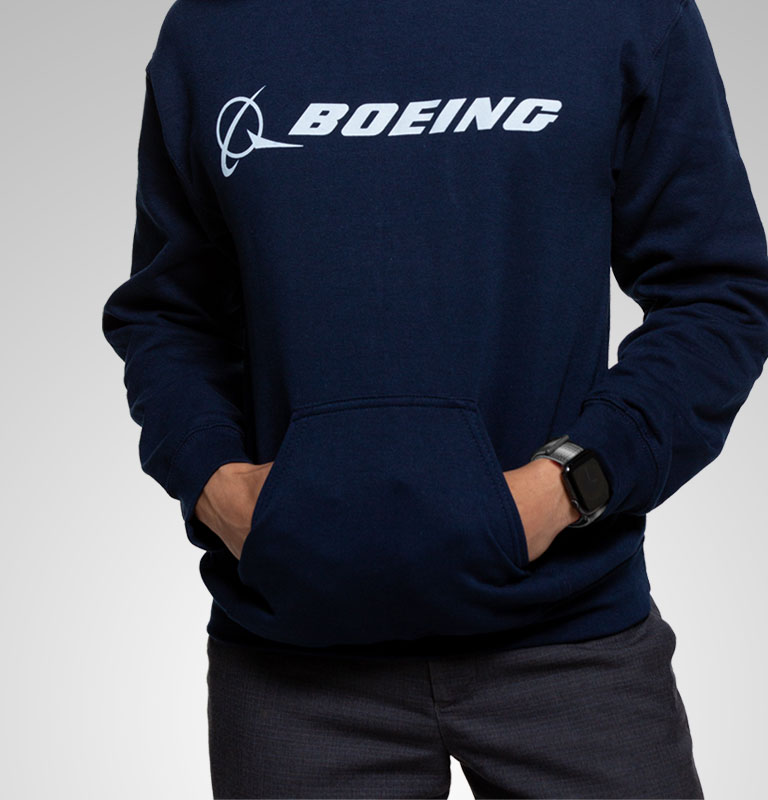 A person wearing a Boeing shirt crossing their arms