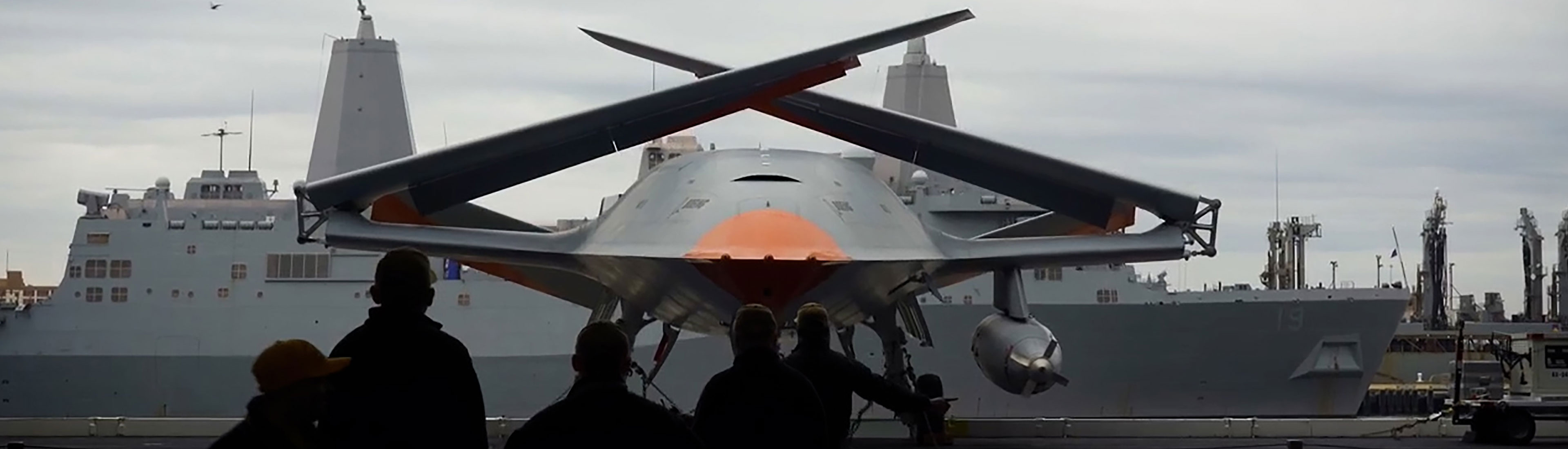 MQ-25 on an aircraft carrier with its wings folded