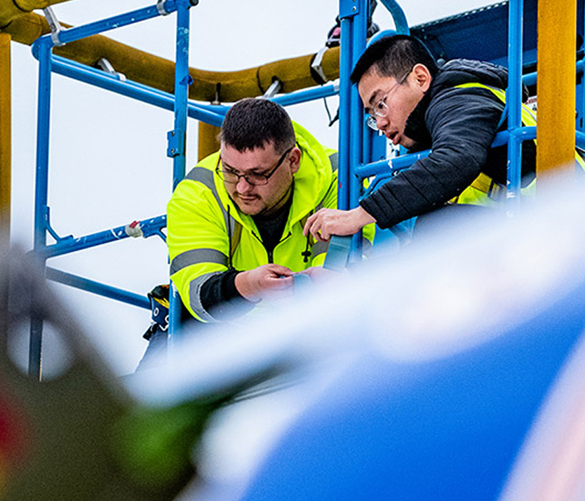 two people working on an aircraft from above the fuselage