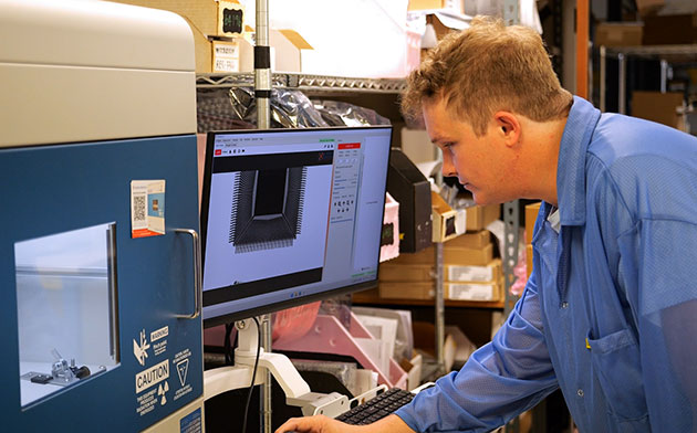 Quality control inspector Robert Rainer inspects a part at Pacific Component Xchange’s warehouse in Huntington Beach, California.